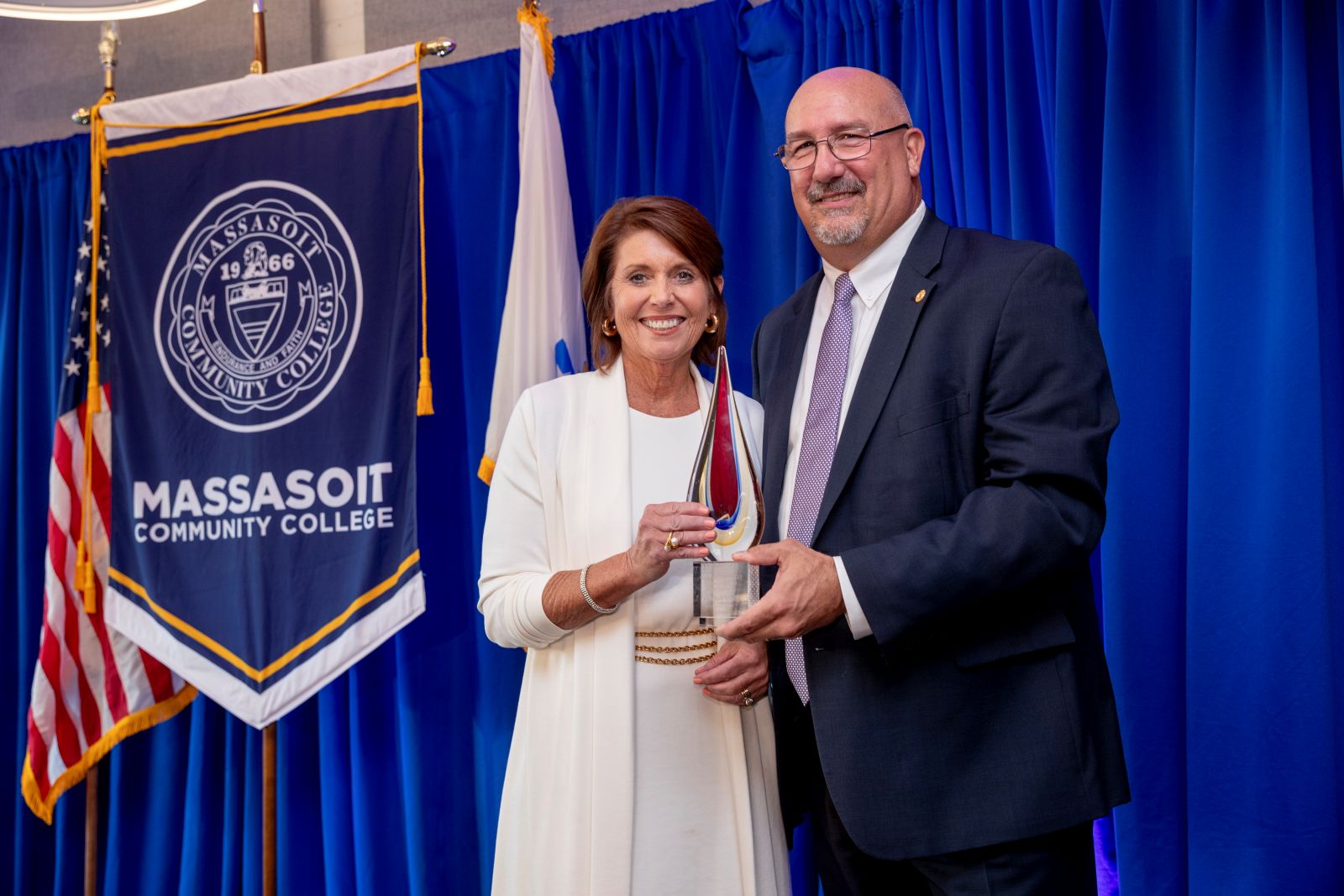 Award recipient being given award by college president.