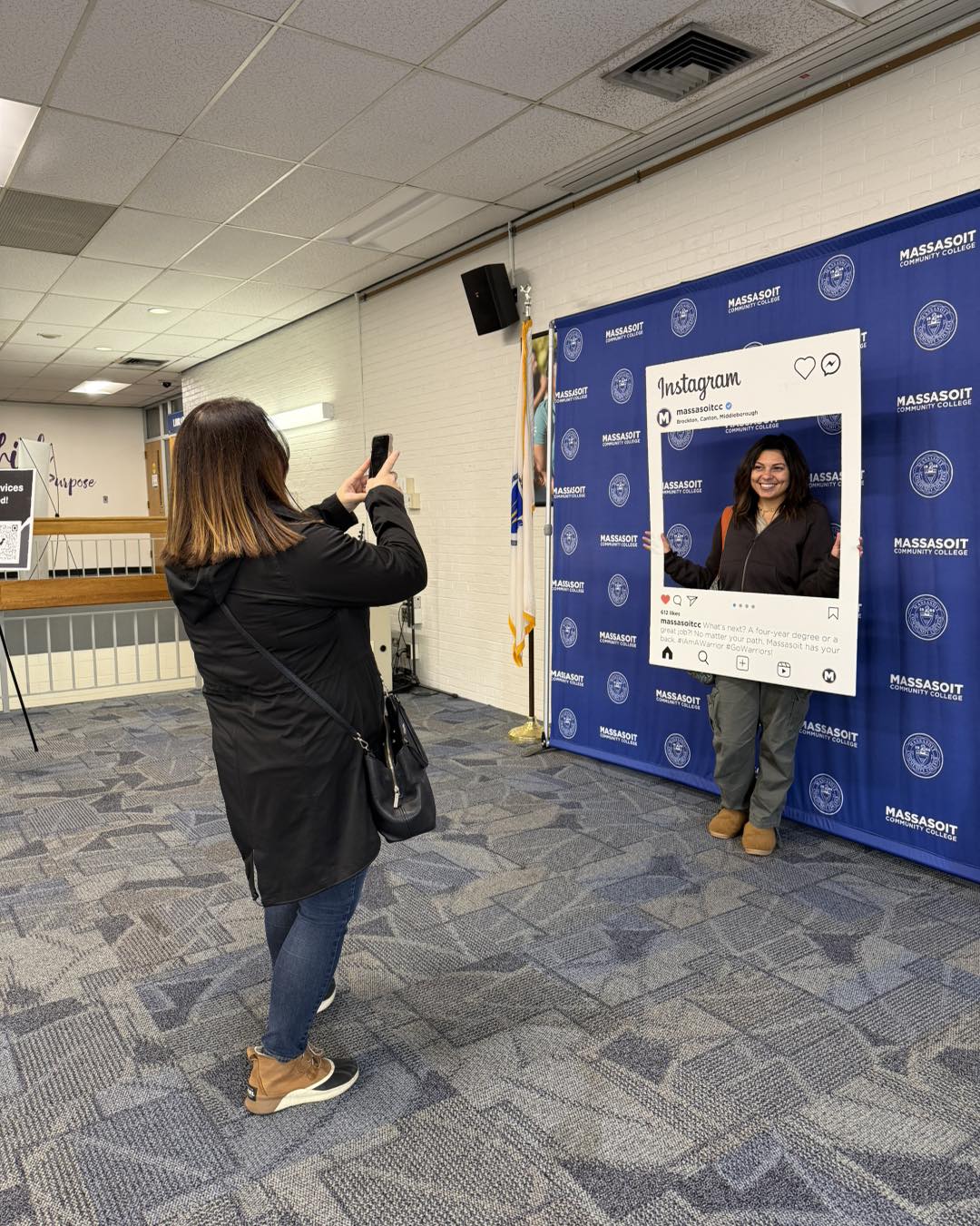 Student having their photo taken while they are holding up an I'm First Generation social media cutout.