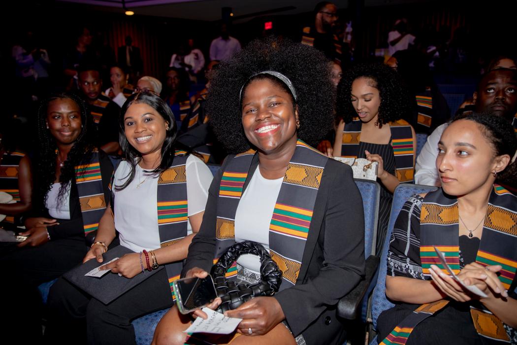 Graduates sitting in a theatre for a ceremony.