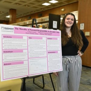 Student posing with research project.