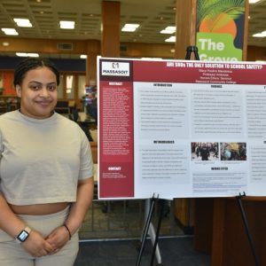 Student posing with research project.