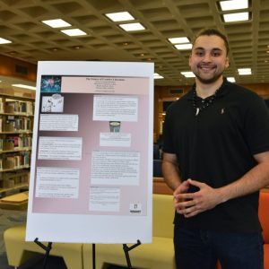 Student posing with research project.