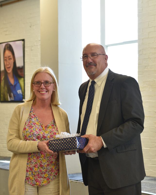 President Mitchell presenting Thomas Frizzell's retirement gift to his daughter, Jen Riley. Thomas Frizzell, a long-time professor and baseball coach at Massasoit, passed away in April 2024.