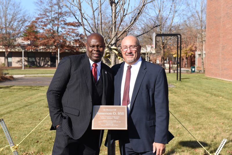 Pamerson Ifill '89 stands with Interim President William Mitchell at a tree dedication in Ifill's honor on the Brockton Campus in November 2024.