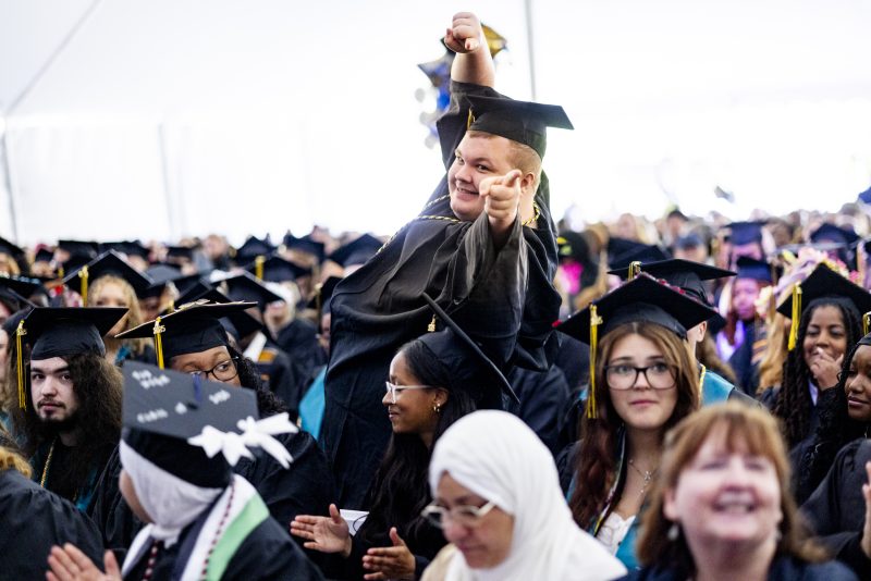 Graduates seated under a tent.